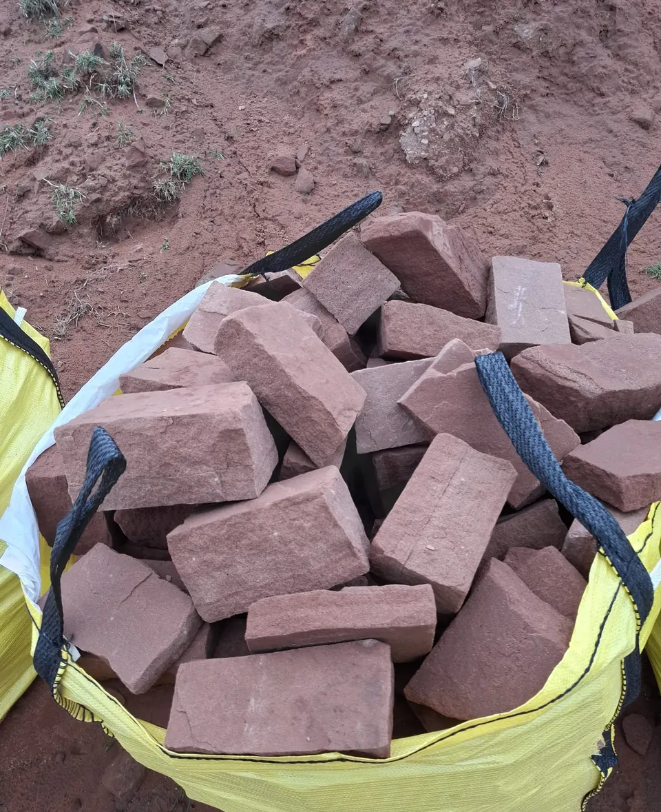 A bulk bag of squared red sandstone facing stone seen from above