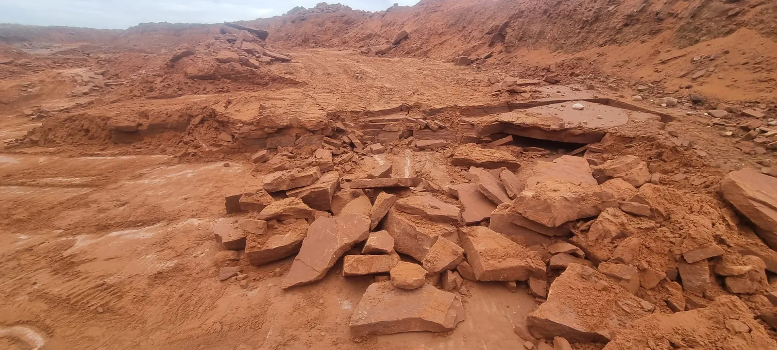 Bedded red sandstone slabs exposed at the quarry face